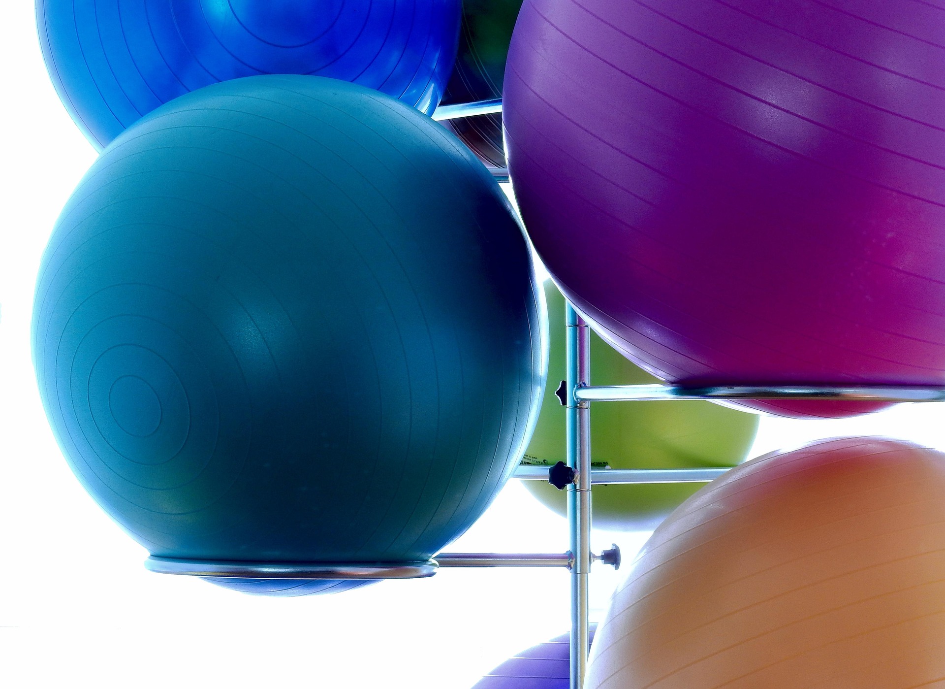 Bunte Gymnastikbälle in einem Halter im Therapieraum